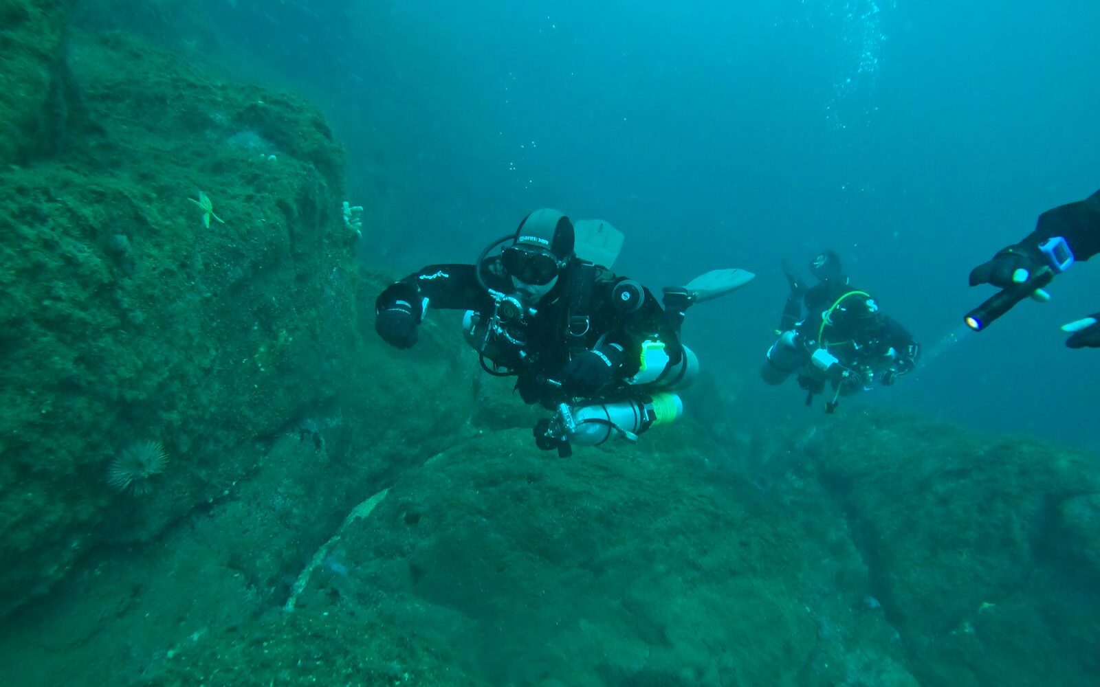 Instructor enseñando técnicas de navegación subacuática con brújula a sus alumnos