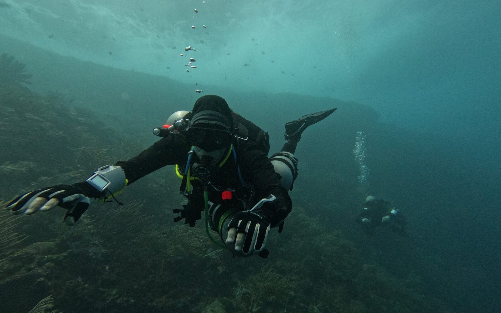 Instructor de sidemount revisando la configuración de doble tanque de un alumno