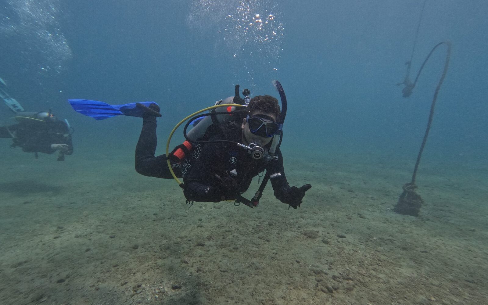 Buzos con linternas explorando el fondo marino de noche, especialidad Buceo Nocturno