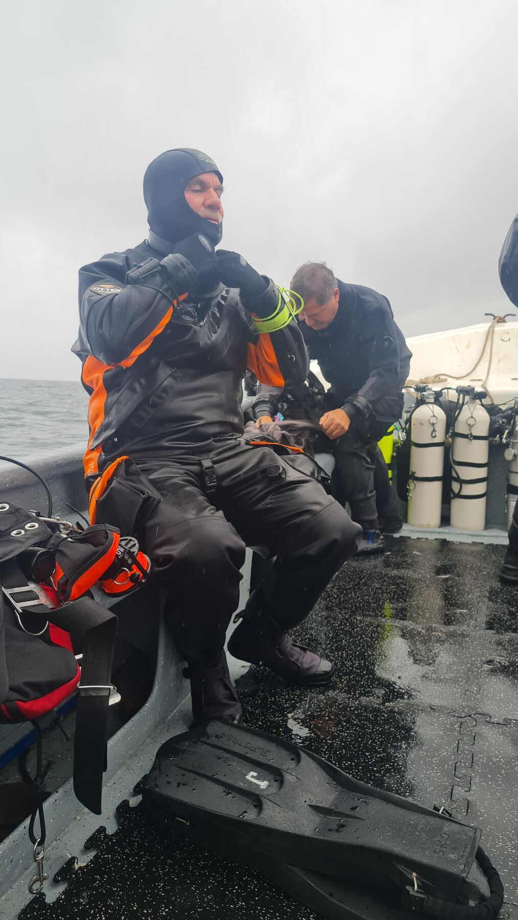 Buzos preparando el equipo bajo la lluvia, sin importar el clima